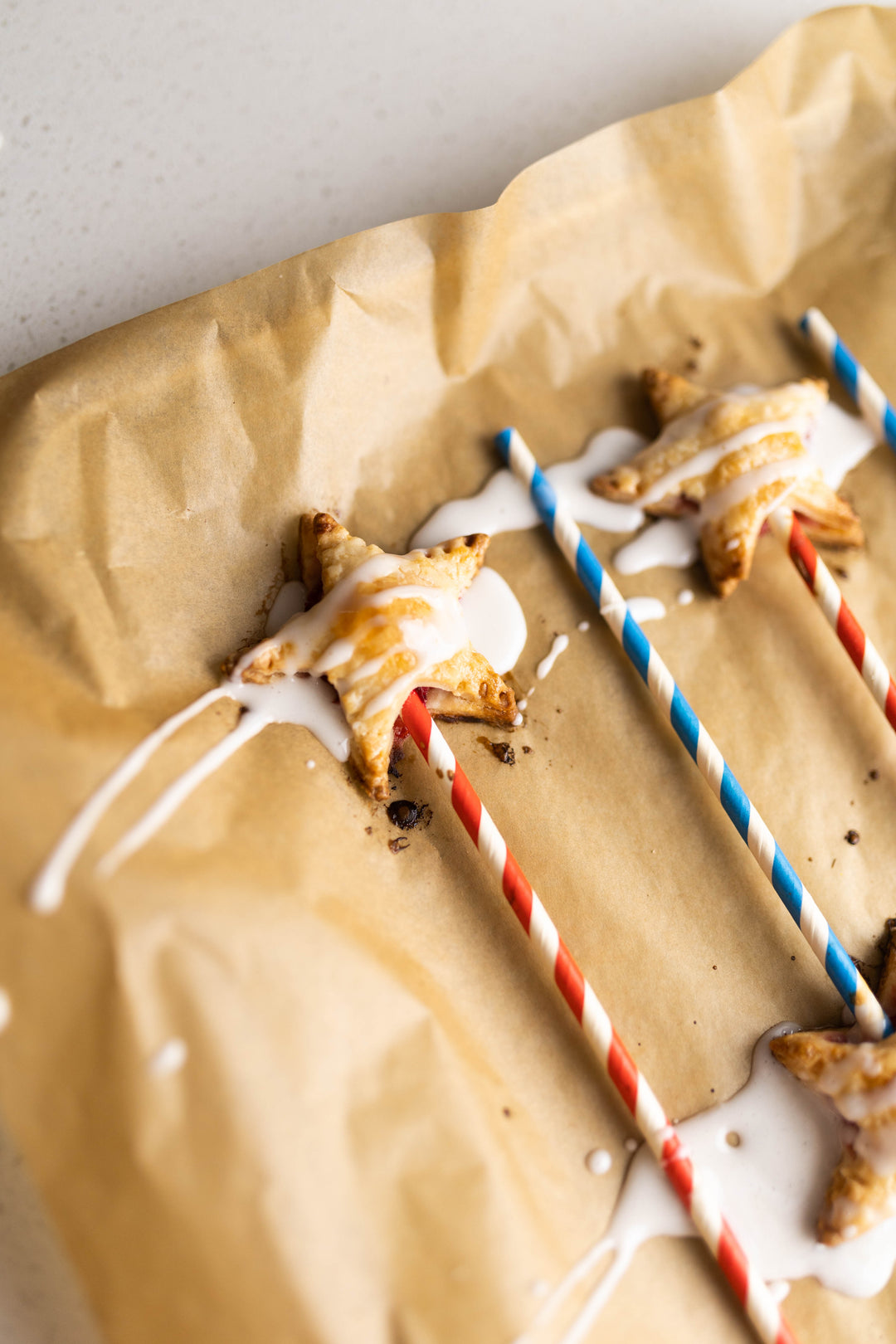Strawberry Star Pie Pops being drizzled with glaze
